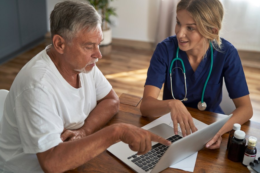 Nurse reviewing health information with a patient at home